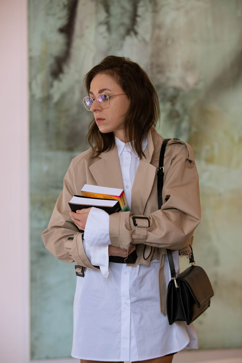 Uczestniczka wernisażu, na rękach trzyma dwie grube książki