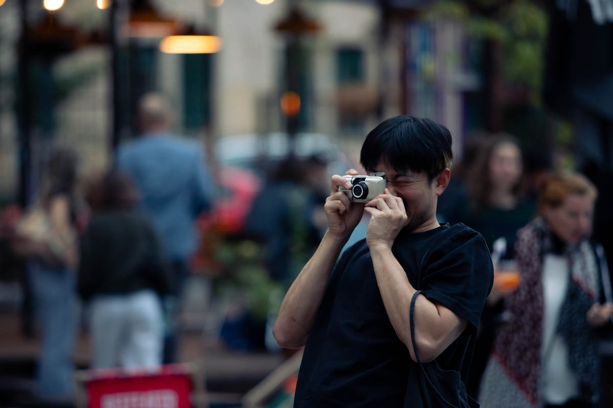 Mężczyzna robiący zdjęcie. W tle wystawa