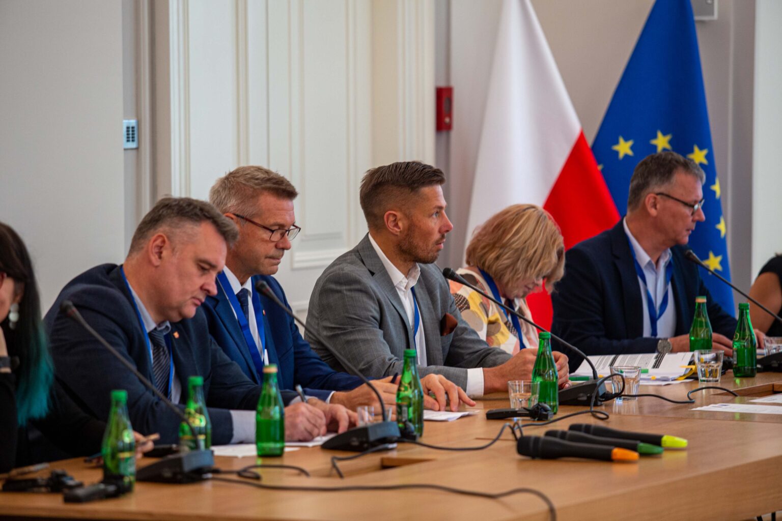 Grupa ludzi siedzących za stołem prezydialnym