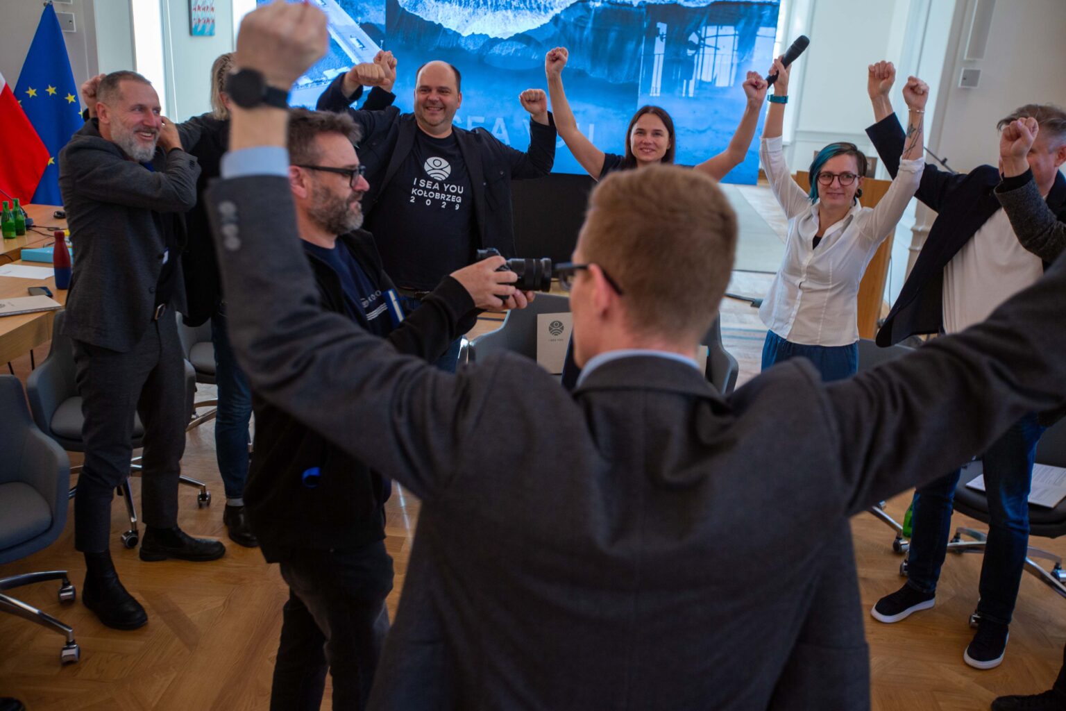 Moment ogłoszenia nominacji. Reprezentanci jednego z miast z uniesionymi rękami w tryumfalnym geście