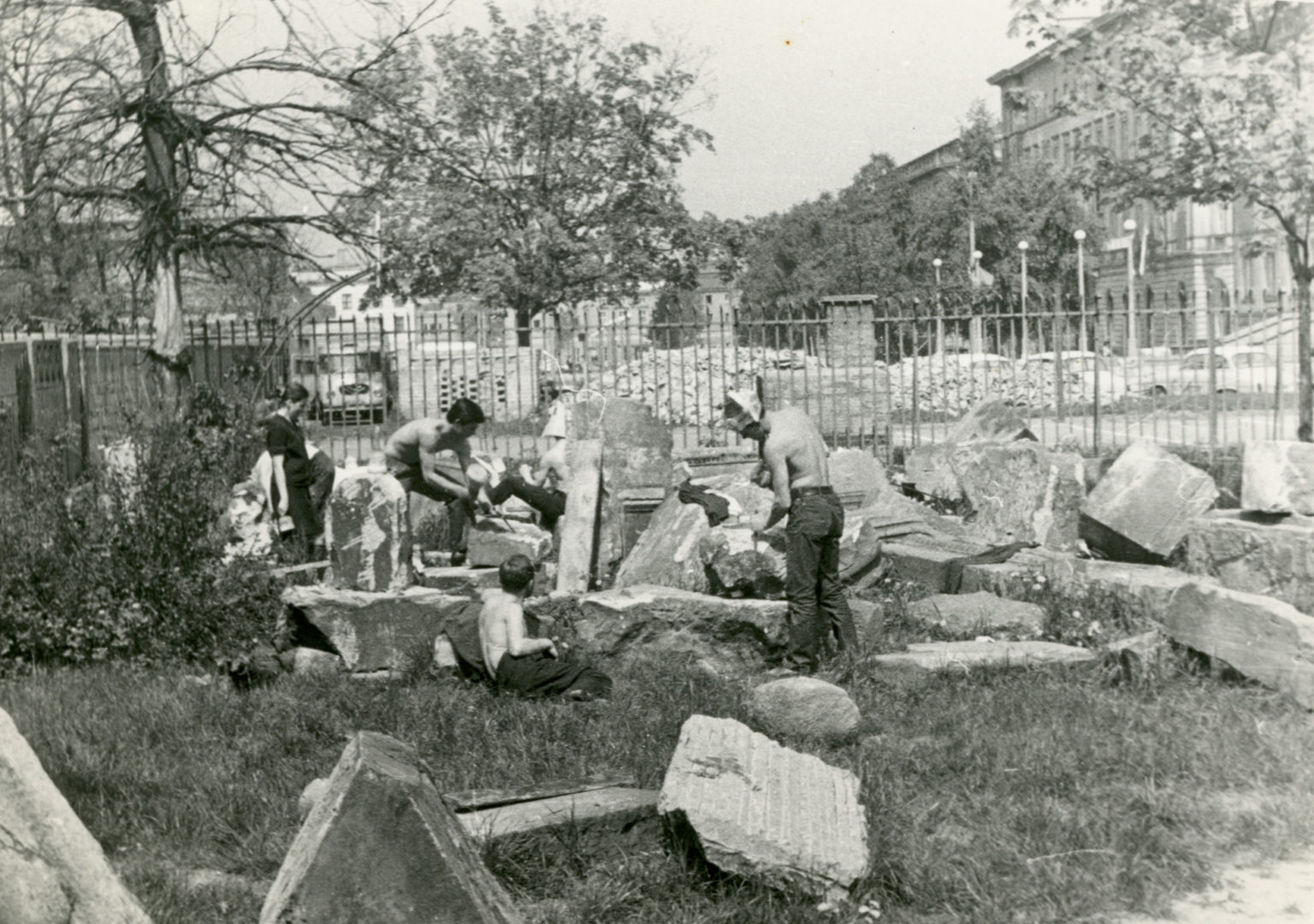 Studenci stoją pośród leżących w trawie fragmentów zdobień