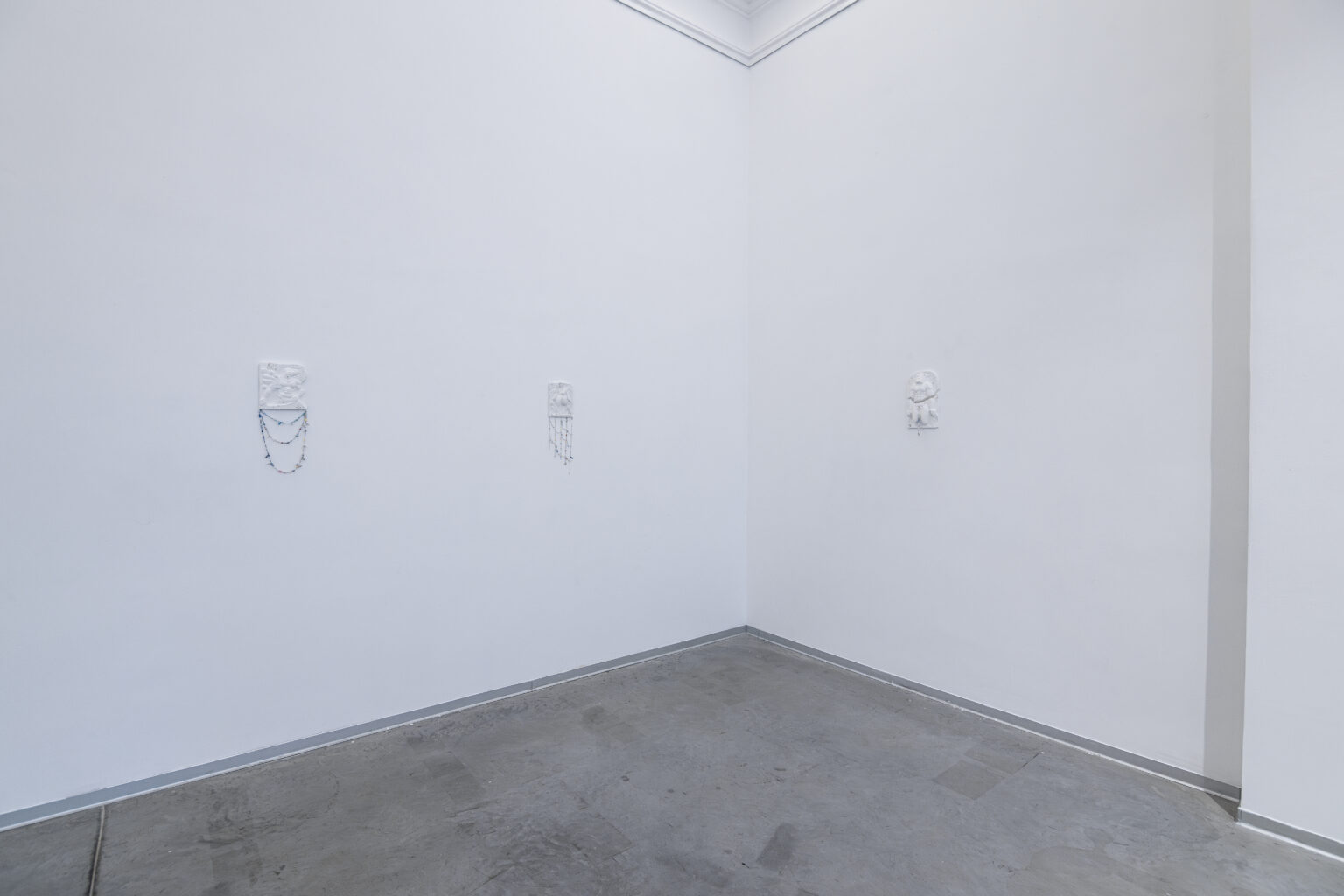 Ceramiczne płaskorzeźby wygenerowane przez sztuczną inteligencję wiszą na ścianach galerii