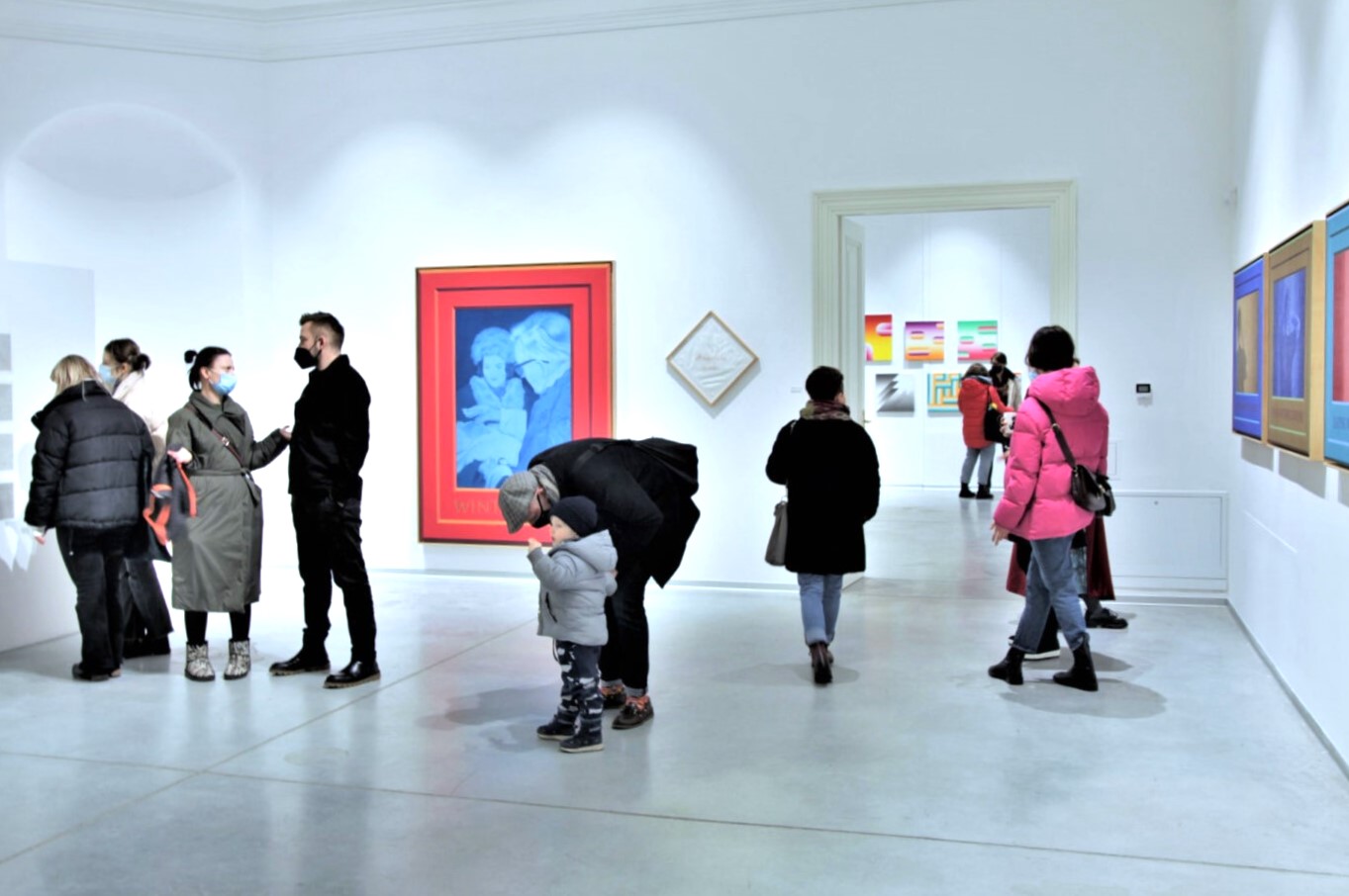 Grupa zwiedzających wystawę ludzi w różnym wieku