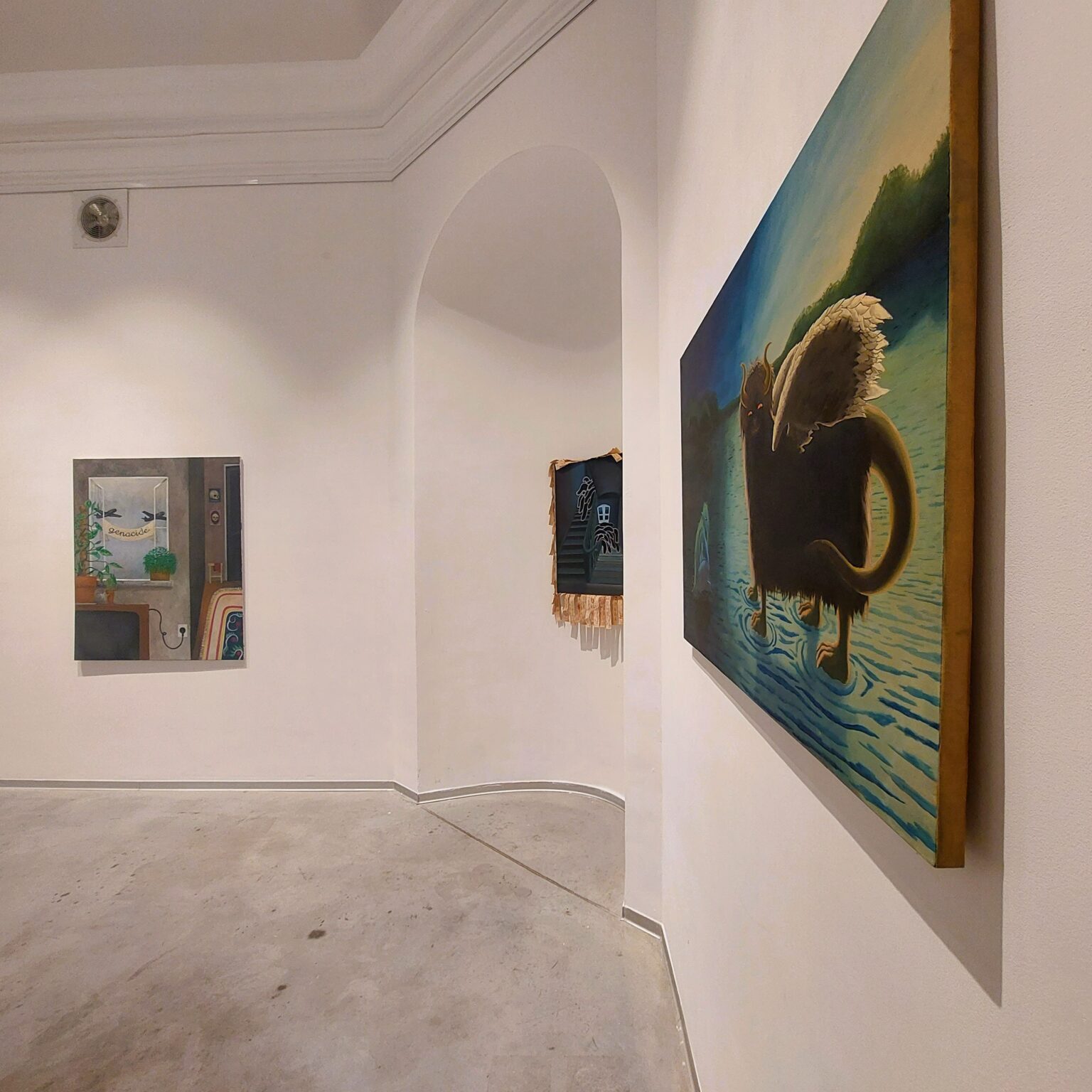 Obrazy wiszące na białych ścianach.