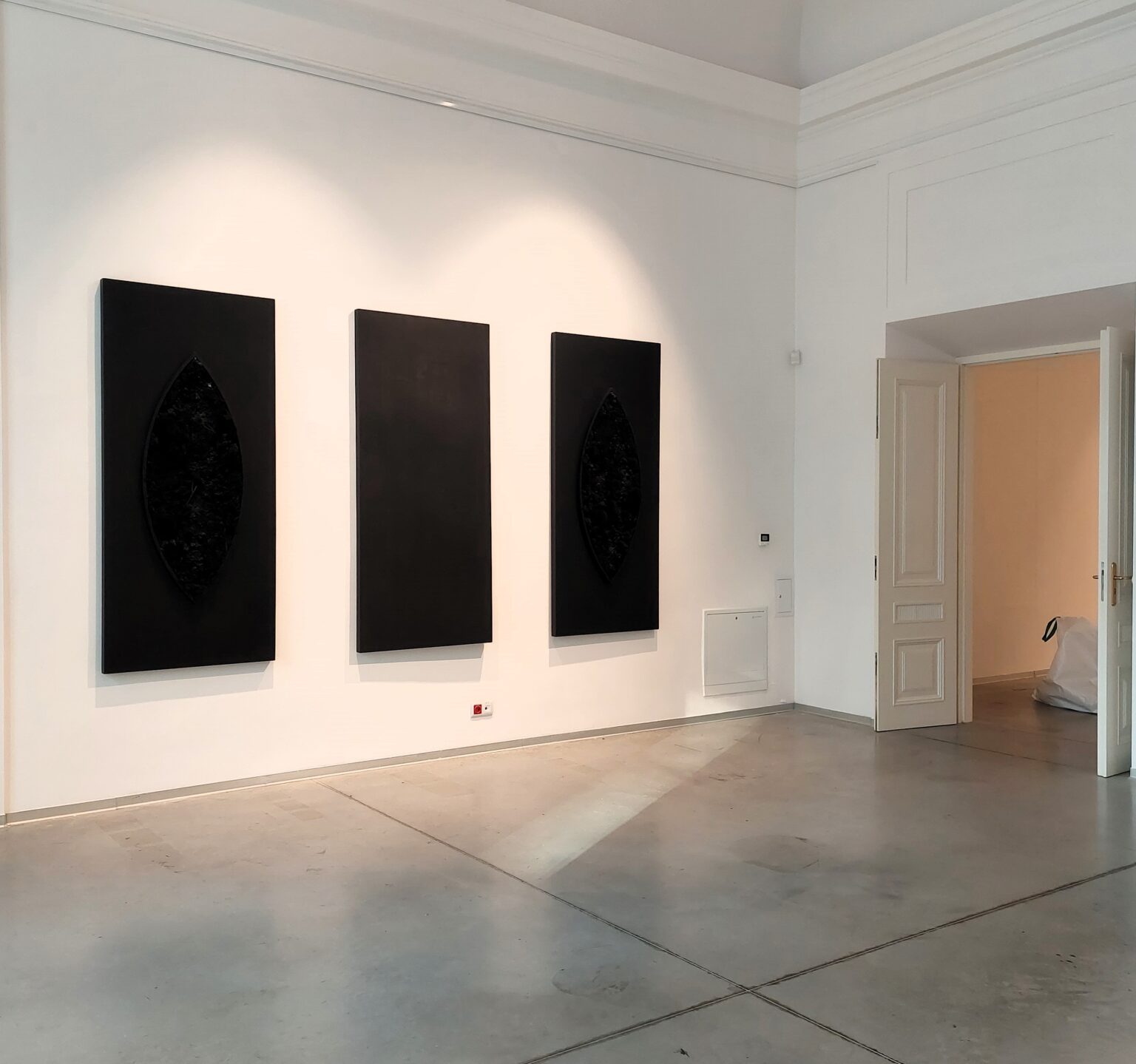 Trzy czarne obrazy wiszące na ścianie.