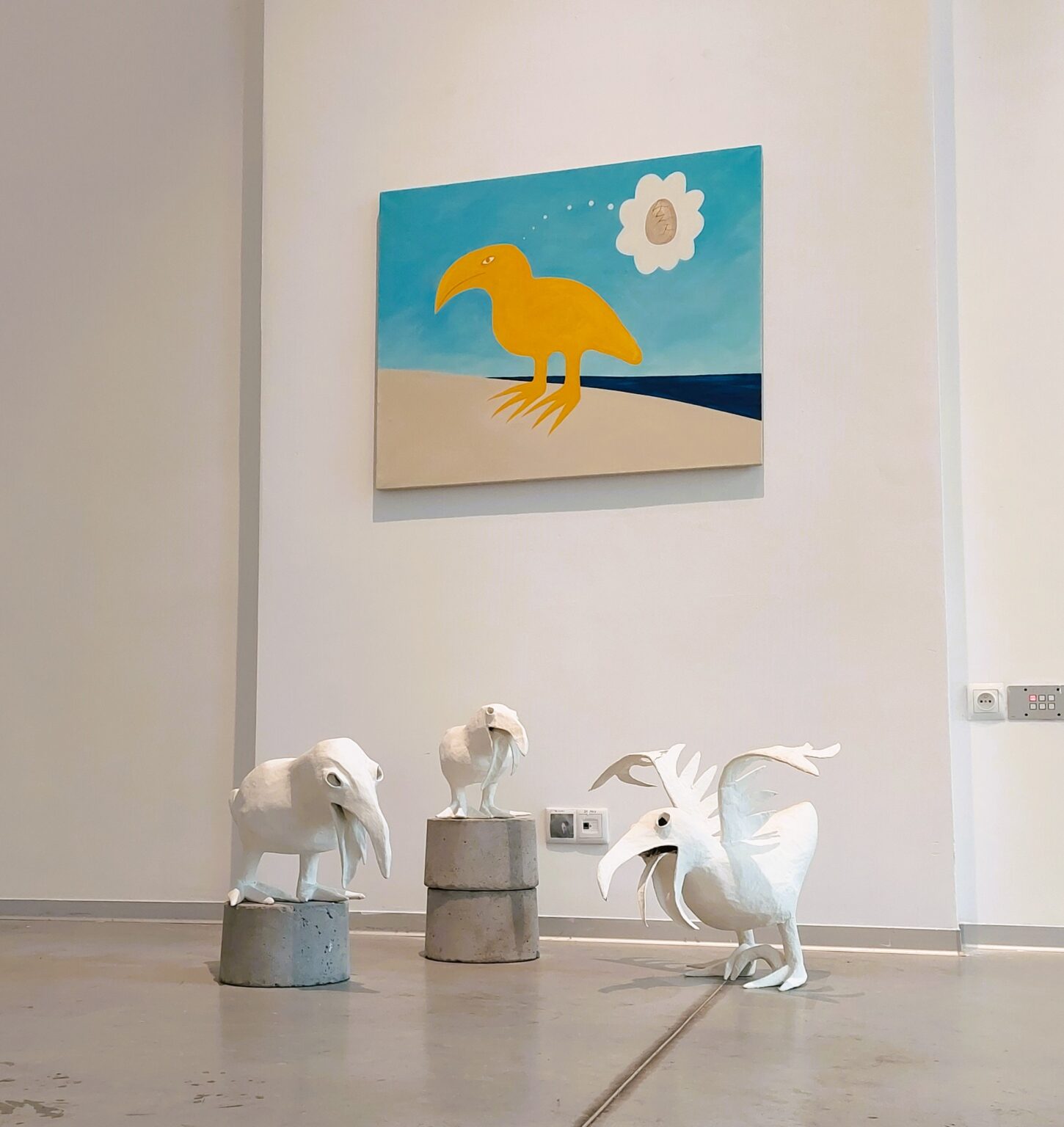 Obraz z ptakiem wiszący na ścianie. Poniżej trzy formy przedstawiające ptaki.