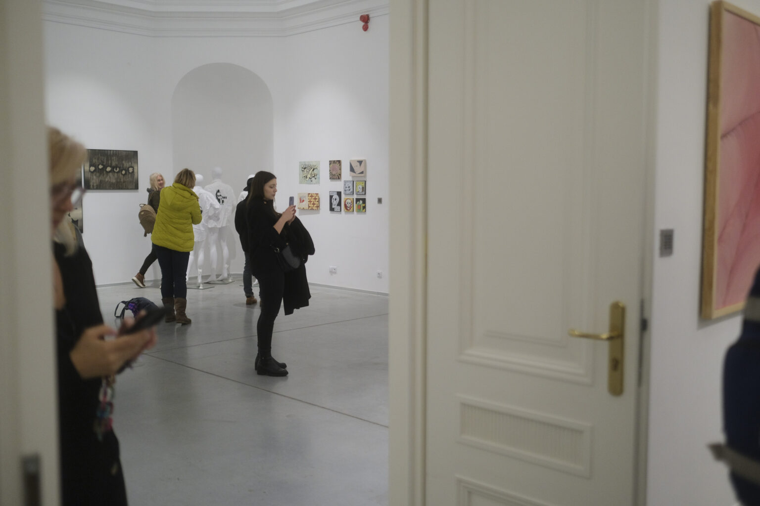 Widzowie wystawy w przestrzeni galerii, na ścianach wiszą prace Konrada Jarodzkiego i Pawła Jarodzkiego