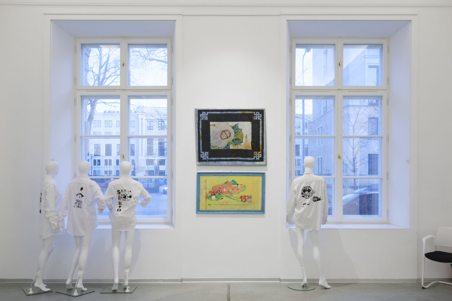 Przestrzeń galerii. Na tle okien stoją manekiny ubrane w koszule z szablonowymi odbitkami prac Pawła Jarodzkiego. Na ścianie pomiędzy oknami wiszą prace Pawła Jarodzkiego.