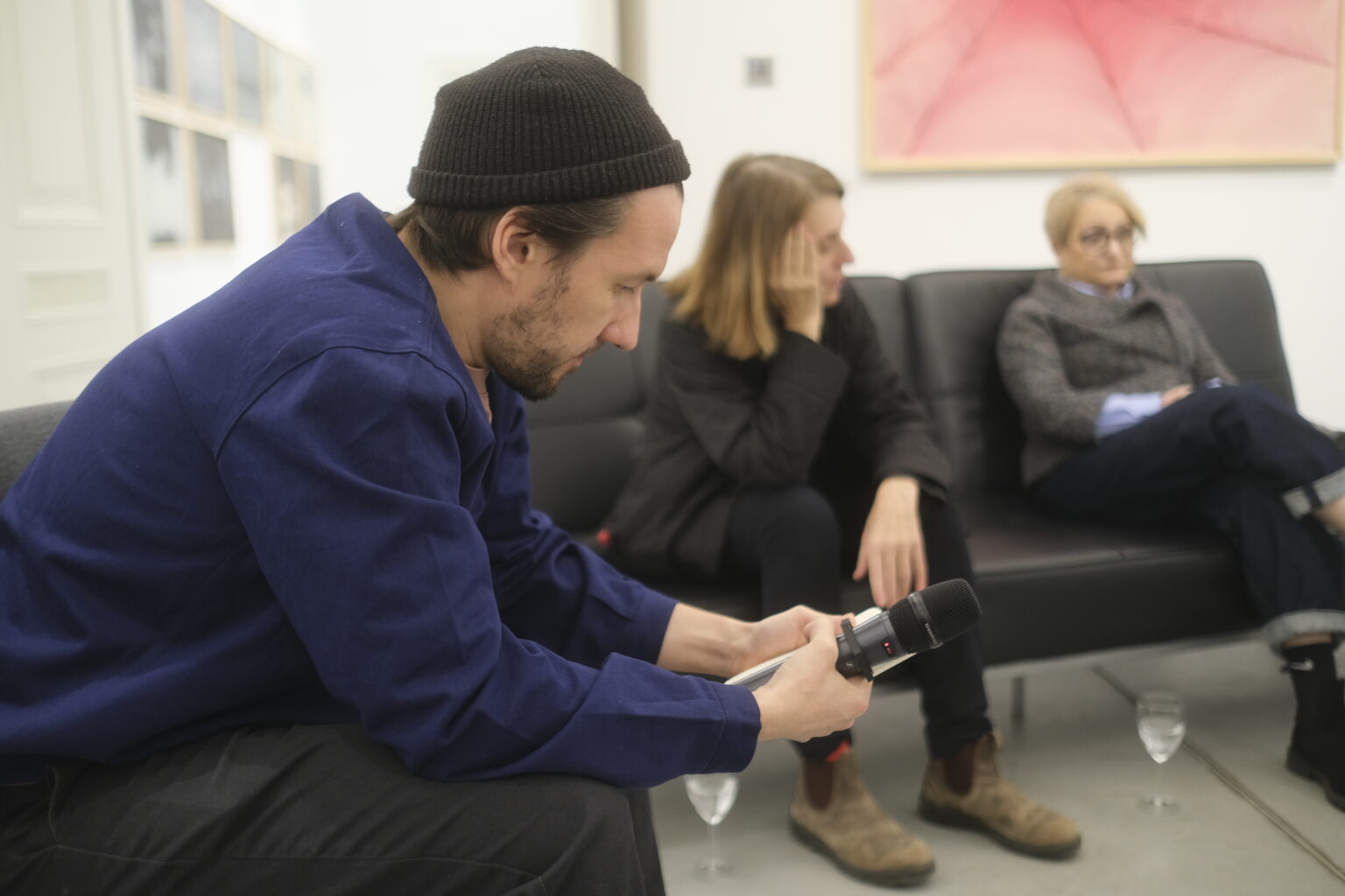 zbliżenie na prowadzącego debatę - Aleksandra Hudzika, w tle siedzi prelegentka Hanna Wróblewska