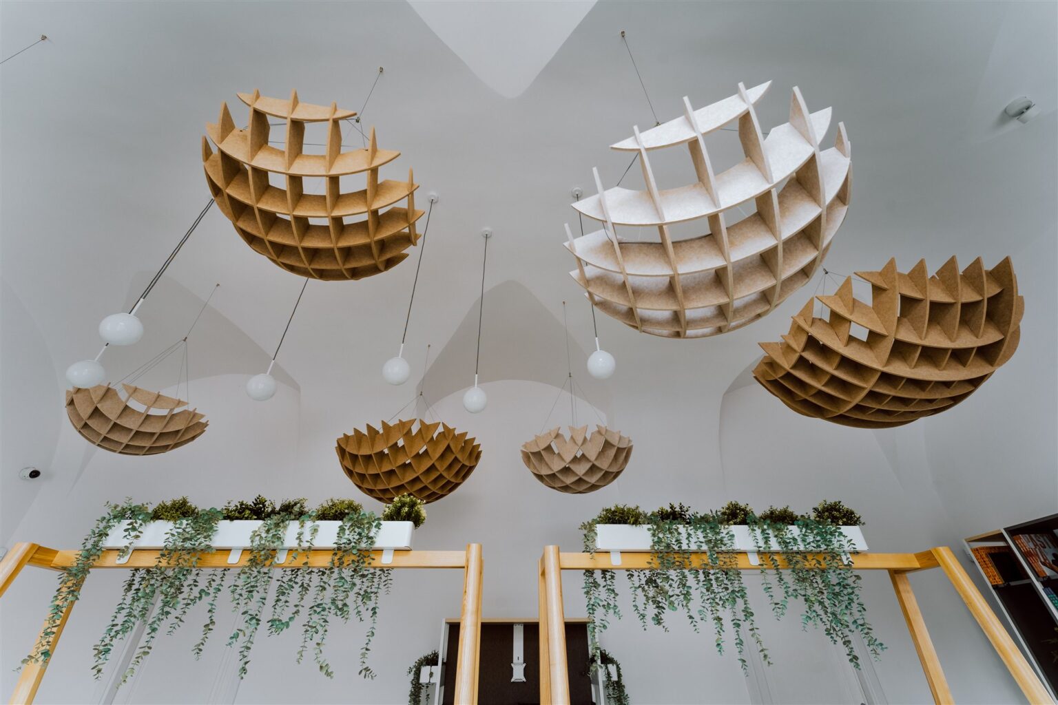 Kuliste ozdoby podwieszone pod sufitem i fragment regału z doniczkami