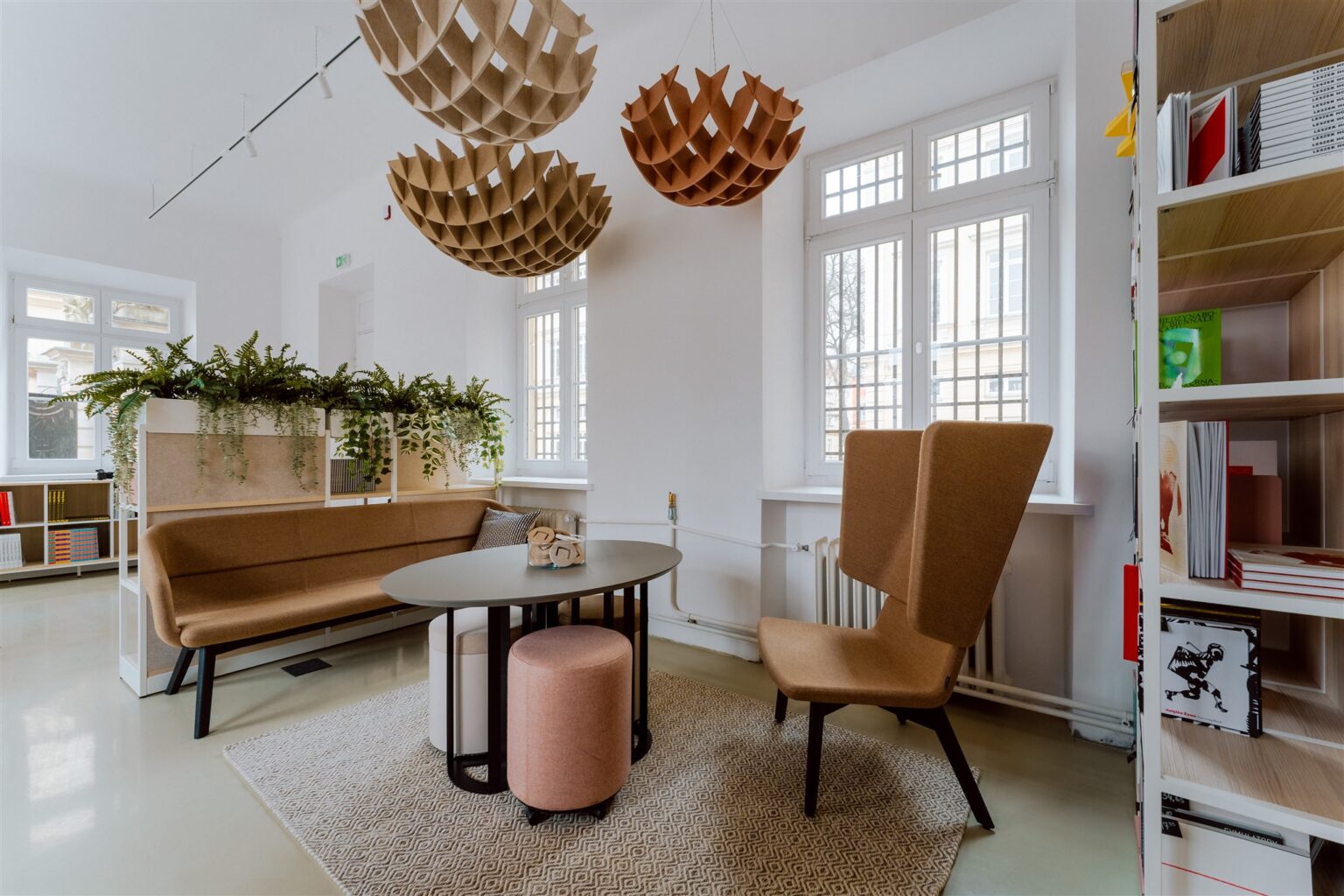 Nowocześnie umeblowane, jasne wnętrze z kulistymi ozdobami podwieszonymi pod sufitem