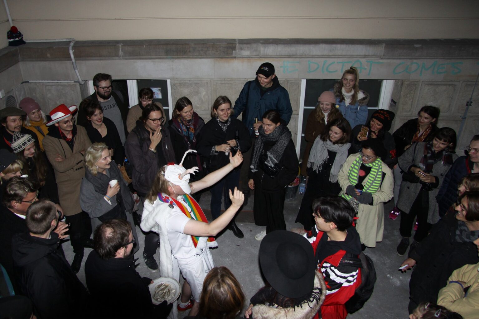 fotografia. widok z góry. grupa młodych ludzi stoi wokół postaci przebranej w biały kostium.